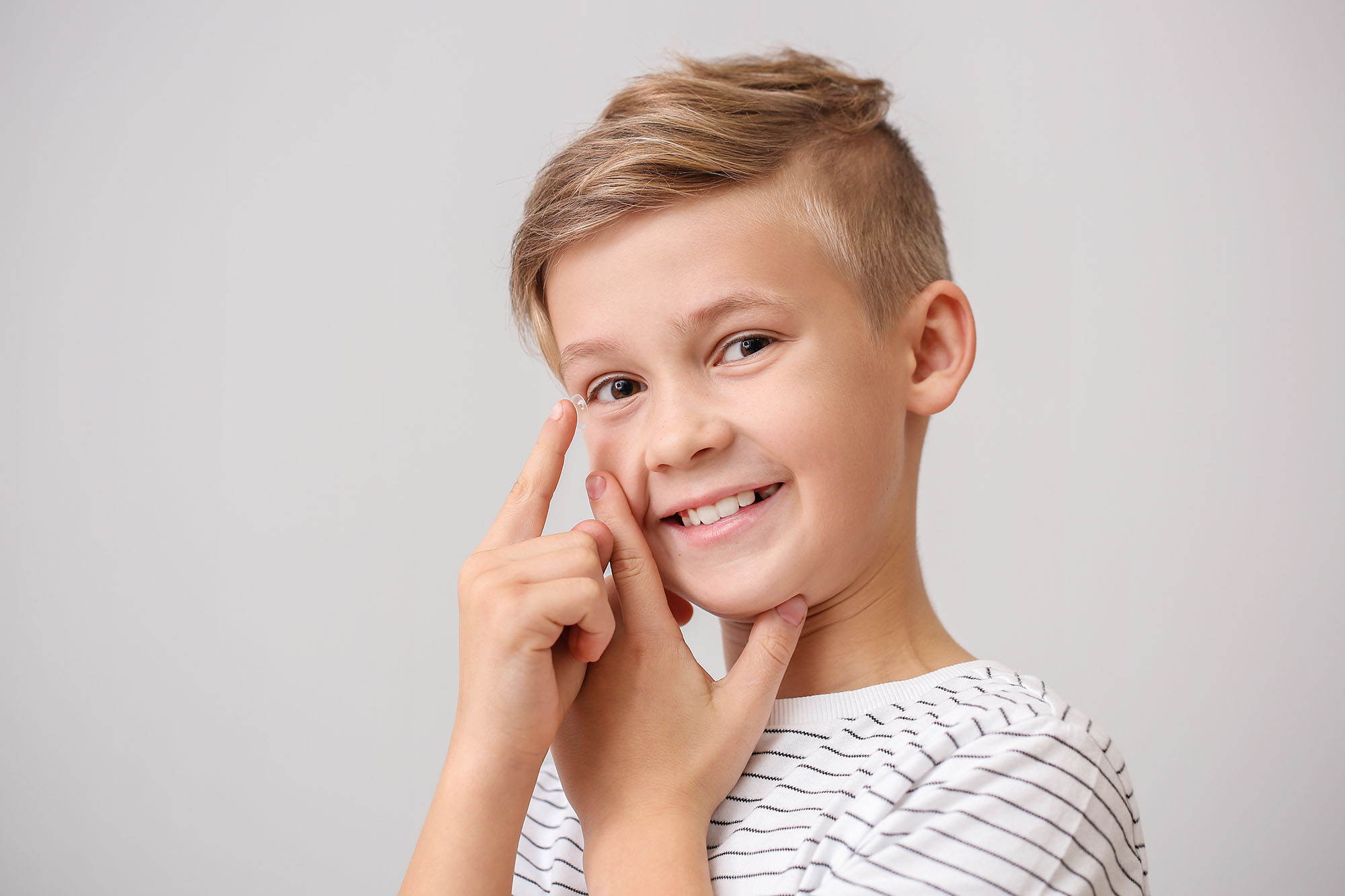 little boy holding a contact lens